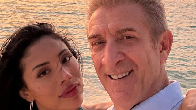 Ezio Greggio e Nataly Ospina sorridono con tramonto sul mare sullo sfondo Ezio Greggio e Nataly Ospina sorridono con tramonto sul mare sullo sfondo